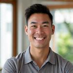 Portrait of Mr. Liam Chen, a confident, approachable male health coach in his late 30s or early 40s with an athletic build and an encouraging smile, wearing smart casual attire in a bright, modern gym or studio setting.