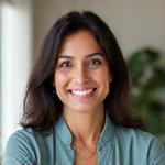 Portrait of Ms. Sara Patel, a compassionate, insightful female therapist or counselor in her early 40s, with a warm, understanding expression, dressed in professional yet comfortable attire, seated in a calming office.
