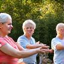 A diverse group of adults moving gracefully in a park, symbolizing accessible fitness
