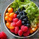 A colorful bowl of fresh berries, nuts, and greens, symbolizing balanced nutrition